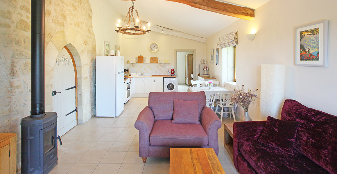 Comfortable gite living area with well equipped kitchen and door through to en suite bedroom