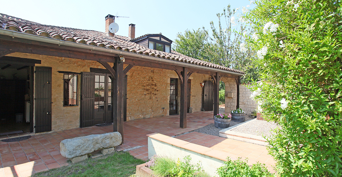 The covered terrace at the side of the house with doors to the kitchen and main hall