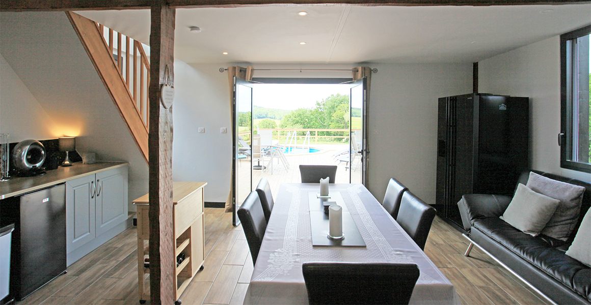 The kitchen dining area opens out onto the large decked terrace and pool